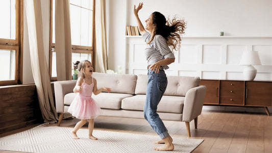 Une femme pleine d'énergie qui danse avec sa fille dans son salon